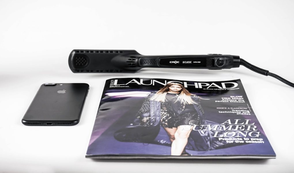 black corded hair flat iron beside magazine