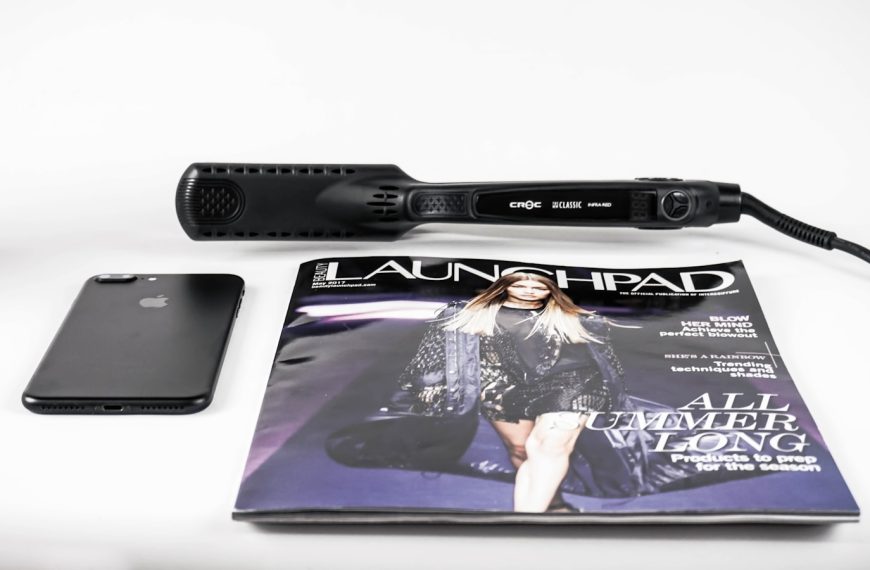 black corded hair flat iron beside magazine